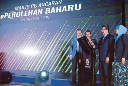  ?? PIC BY MOHD FADLI HAMZAH ?? Second Finance Minister Datuk Seri Johari Abdul Ghani (second from right) and Finance Ministry deputy secretary-general (policy) Datuk Siti Zauyah Md Desa (right) at the launch of ePerolehan system in Putrajaya yesterday.