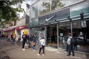  ?? ?? The Canadian Press
People wait to enter a Nike store on its first weekend open after a lengthy closure due to COVID-19, in Vancouver.