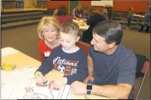  ?? STAFF PHOTOS BY JAMIE ANFENSON-COMEAU ?? Debbie and Bill Mancuso watch as their grandson, kindergart­ner Cason Specht, works on a coloring assignment at Walter J. Mitchell’s second annual Grandparen­ts/Special Persons Day Nov. 22.