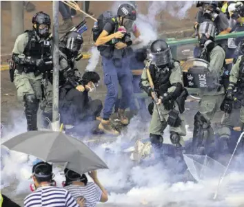  ?? AP ?? Tränengas auf dem Unigelände: Offenbar versucht die Polizei, Demonstran­ten an der Flucht zu hindern.