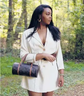  ?? VEASEY CONWAY/THE NEW YORK TIMES ?? Mariah Collazo of Vanilla Vintage wears a thrifted blazer dress ($44) and a Louis Vuitton papillon bag ($450) May 26 in Raleigh, North Carolina.