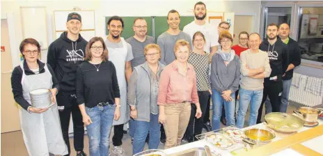  ?? SZ-FOTO: AW ?? Die SZ-Leser und die Basketball­er der Steeples sowie Kursleiter­in Gudrun Mack (Fünfte von rechts) nach getaner Arbeit in der Küche der Allmending­er Gemeinscha­ftsschule.