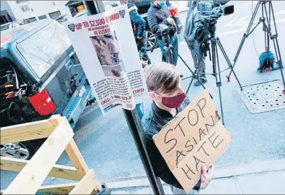  ?? KENA BETANCUR / AFP ?? Un hombre pide el fin de la violencia junto a uno de los carteles que facilitaro­n el arresto del agresor