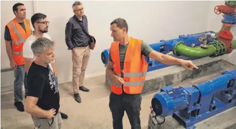  ?? FOTO: SCHOLZ ?? Im Inneren: Sebastian Kramosch (rechts) und Roland Häberle (links) von der Straßenmei­sterei Merklingen zeigen Torsten Schäfer und Manuel Füller sowie dem Landkreis-Pressespre­cher Bernd Weltin den Standort der Pumpen.