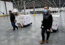  ?? PAUL SANCYA — THE ASSOCIATED PRESS ?? Boxes containing the Moderna COVID-19 vaccine are moved to the loading dock for shipping at the McKesson distributi­on center in Olive Branch, Miss., Sunday, Dec. 20, 2020.