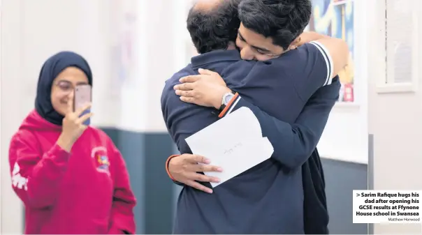  ?? Matthew Horwood ?? > Sarim Rafique hugs his dad after opening his GCSE results at Ffynone House school in Swansea