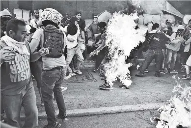  ?? AFP ?? Momento en que Orlando Figuera es quemado en el este de Caracas, el sábado. El joven está en estado crítico.