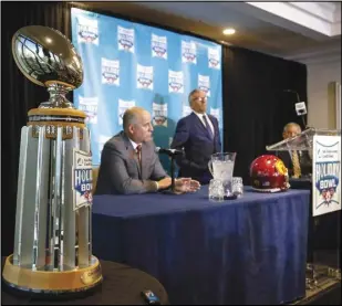  ?? Associated Press ?? HOLIDAY PRESS — The Holiday Bowl trophy towers in the foreground as USC head football coach Clay Helton and Iowa head football coach Kirk Ferentz speak to members of the media about the 2019 Holiday Bowl during a press conference on Thursday in San Diego.