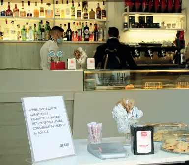 ??  ?? Caffè non al banco L’interno di un bar a Bari con l’indicazion­e dei divieti previsti dal nuovo decreto