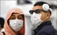  ?? MARCO UGARTE / ASSOCIATED PRESS ?? MEXICO: A couple take precaution­s Friday against the new coronaviru­s at the airport in Mexico City. Mexico’s assistant health secretary announced Friday the nation now has confirmed cases of the COVID-19 virus.