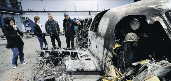  ?? MARK VAN MANEN/FILES ?? The family of Matthew Robic, a co-pilot who died in a 2011 air crash, survey the wreckage. Two people died in B.C. air crashes last year and four are still missing.