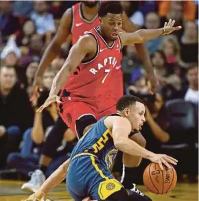  ?? AFP PIC ?? Raptors’ Kyle Lowry (No 7) guards as Warriors’ Stephen Curry is down during their game in Oakland on Wednesday.