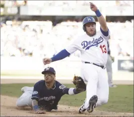  ?? The Associated Press ?? Milwaukee Brewers’ Orlando Arcia tags out Los Angeles Dodgers’ Max Muncy during National League Championsh­ip Series action. The Brewers won 7-2 on Friday night.