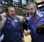  ?? RICHARD DREW — THE ASSOCIATED PRESS ?? Specialist Charles Boeddingha­us, left, and trader Kevin Lodewick work on the floor of the New York Stock Exchange, Friday. Stocks are moving higher in early trading on Wall Street after the government reported solid job gains in the U.S. a month earlier.