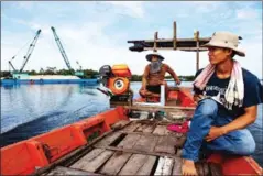  ?? ATHENA ZELANDONII ?? Two Mother Nature activists travel past moored sand dredgers as they inspect the condition of the Tatai River last year in Koh Kong province.