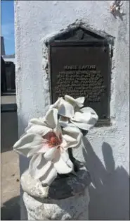  ?? BETH J. HARPAZ — THE ASSOCIATED PRESS ?? This June 3, 2018 photo shows an offering and plaque marking the tomb for Marie Laveau at St. Louis Cemetery No. 1 in New Orleans. The marker calls her the “notorious voodoo queen ... the most widely known of many practition­ers of the cult.” She died in 1881.