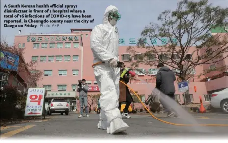  ??  ?? A South Korean health official sprays disinfecta­nt in front of a hospital where a total of 16 infections of COVID-19 have been reported, in Cheongdo county near the city of Daegu on Friday.