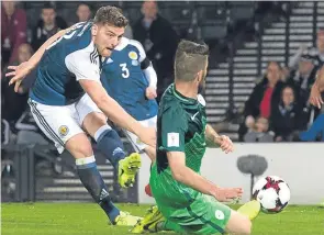  ??  ?? Chris Martin fires in Scotland’s late winner against Slovenia.