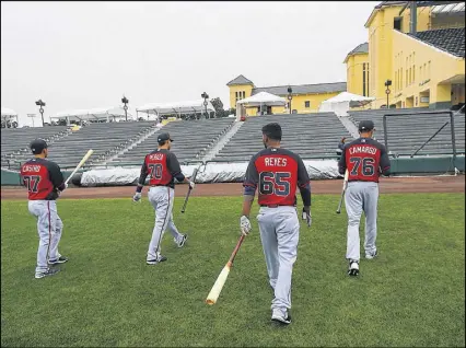  ?? CURTIS COMPTON / CCOMPTON@AJC.COM ?? The Braves’ Daniel Castro, Jose Peraza, Elmer Reyes and Johan Camargo head to work in Champion Stadium as the full team reported for spring training Wednesday.