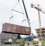  ?? DARREN STONE, TC ?? A refurbishe­d boxcar, purchased from a railway historical group in Parksville is lowered into position at Bayview Place.