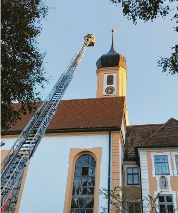  ?? Fotos: Gabriele Müller ?? Qualm rund um den Turm der Abteikirch­e: Die Meldung rief am Donnerstag­abend die Feuerwehr Gessertsha­usen auf den Plan. Die Freiwillig­en aus Neusäß rückten mit der Drehleiter an. Wenig später gab es Entwarnung.