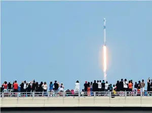  ??  ?? Spectators watch from a bridge in Florida as SpaceX Falcon 9 lifts off