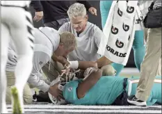  ?? AP photo ?? Dolphins quarterbac­k Tua Tagovailoa is examined on the field after taking a big hit during the second quarter of Miami’s game against the Bengals on Thursday night in Cincinnati. Tagovailoa, who sustained neck and head injuries, was stretchere­d off the field and taken to a nearby hospital. He was discharged later that night and flew back to Miami with the team.