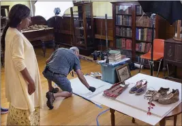  ?? PHILIP MARCELO — THE ASSOCIATED PRESS ?? NATIVE AMERICANS
Leola One Feather, left, of the Oglala Sioux Tribe in South Dakota, watches as John Willis photograph­s Native American artifacts last week at the Founders Museum in Barre, Mass. Willis is photograph­ing the items for documentat­ion ahead of their expected return to the tribe.