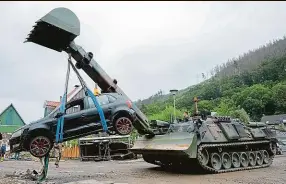  ??  ?? Vojenská operace. Vyprošťova­cí tank ženistů Bundeswehr­u odváží zničené auto v německém městě Hagen. Proudy vod tam odnášely vše – i celé domy. Foto: ČTK