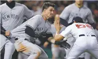  ?? CHARLES KRUPA THE ASSOCIATED PRESS ?? The Yankees’ Tyler Austin, center, rushes the Red Sox relief pitcher Joe Kelly, right, as they fight during the seventh inning of Wednesdsay’s game at Fenway Park in Boston.