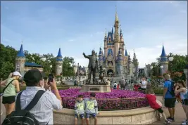  ?? TED SHAFFREY — THE ASSOCIATED PRESS FILE ?? People visit the Magic Kingdom Park at Walt Disney World Resort in Lake Buena Vista, Florida, on April 18.