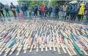  ?? JASON PAYNE/PNG ?? More than 2,000 stakes, many inscribed with the names of people who died from opioid overdoses, were displayed Friday in Oppenheime­r Park in the Downtown Eastside.