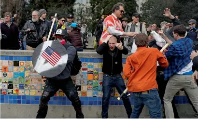  ?? Reuters ?? A demonstrat­or supporting President Trump (left) holds a shield as a group of men punch an opponent during a ‘People 4 Trump’ rally in Berkeley, California.—