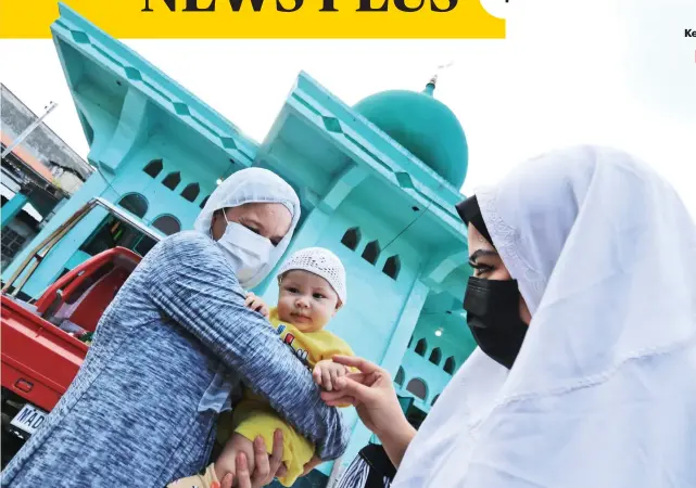  ?? / ALAN TANGCAWAN ?? CELEBRATIN­G. LapuLapu City Barangay Pajo Councilor Jasmine Chan (right) greets baby Mu’min Ibn Zubair Tago as she joins the Muslims at the Islam Masjid Lacima Mosque in Pajo in celebratin­g Eid al-Fitr, the end of Ramadan, on May 13, 2021.