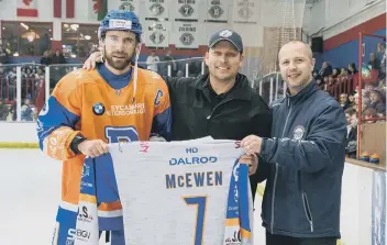  ??  ?? One of Peterborou­gh ice hockey’s greatest imports Doug McEwen (centre) is presented with a Phantoms shirt by coach Slava Koulikov and captain James Ferrara