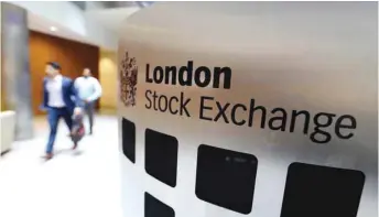  ??  ?? Visitors pass a sign inside the London Stock Exchange Group headquarte­rs. The FTSE 100 closed 0.9% down at 7,040.68 points yesterday.