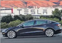  ?? HANDOUT PHOTO COURTESY OF AP ?? Electric automaker Tesla has produced its first Model 3 sedan, a highly anticipate­d car because it carries a relatively low sticker price. On Saturday, CEO Elon Musk tweeted pictures of the car, which will cost $35,000 and can travel 215 miles on a...