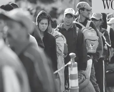  ?? GREGORY BULL/THE ASSOCIATED PRESS ?? Central American migrants wait in line for a meal at a shelter in Tijuana, Mexico, on Wednesday as the first sizable groups in the caravan fleeing violence in their home countries began arriving in the border city of Tijuana.