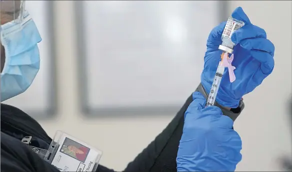  ?? THE ASSOCIATED PRESS ?? A nurse prepares a COVID-19 vaccine.