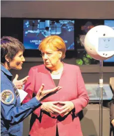  ?? FOTO: ALEXANDER TUTSCHNER ?? ISS-Astronauti­n Samantha Christofor­etti (links) erläutert bei der Raumfahrta­usstellung in Berlin Kanzlerin Angela Merkel die Funktionen des mobilen Astronaute­n-Assistente­n Cimon.