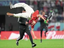  ?? — AP ?? You can’t catch me: a pitch invader does the somersault to escape from security during the Tunisia vs France match.