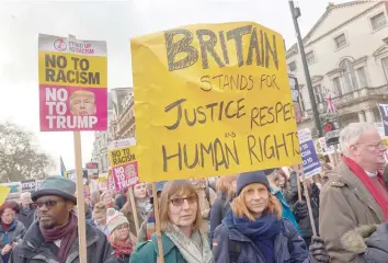  ?? — AFP ?? Demonstrat­ors holding placards march in central London during a protest against US President Donald Trump on Saturday.