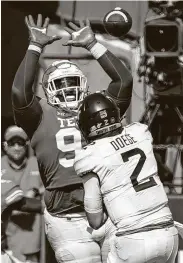  ??  ?? Texas’ T’Vondre Sweat goes up to deflect a pass by West Virginia’s Jarret Doege in the second half.