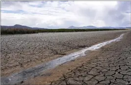  ?? NATHAN HOWARD — THE ASSOCIATED PRESS, FILE ?? A small stream runs through the dried, cracked earth of a former wetland near Tulelake on June 9, 2021.