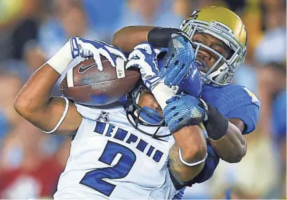  ?? THE ASSOCIATED PRESS ?? Memphis wide receiver Joe Craig, below, makes a catch as UCLA defensive back Fabian Moreau tackles him during the first half of an NCAA college football game, Saturday, Sept. 6, 2014, in Pasadena, Calif.