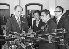  ??  ?? Yong (left) and Azharuddin looking at one of drones showcased at the symposium.