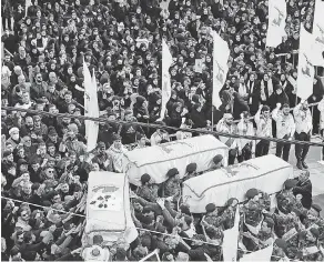  ?? MOHAMMAD ZAATARI/ AP ?? Hezbollah fighters carry the coffins of a comrade and two civilians who were killed by an Israeli airstrike that hit their house in Bint Jbeil, South Lebanon, on Wednesday.