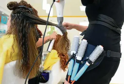  ?? Eine Friseurin föhnt einer Kundin im Salon die Haare. Archiv-foto: Britta Pedersen, dpa ??