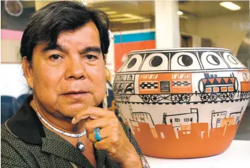  ??  ?? Artist Robert Tenorio of Kewa Pueblo shows his traditiona­l pot, Going to the Market, at the 2003 Santa Fe Indian Market. Tenorio said he has taken part in the market regularly since the 1960s. This year, he’s on a waitlist for a spot at the August...