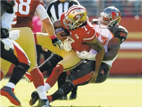  ?? NHAT V. MEYER/STAFF ?? 49ers quarterbac­k Colin Kaepernick is sacked by the Buccaneers' William Gholston in the first quarter, one of four Tampa Bay sacks on the day.